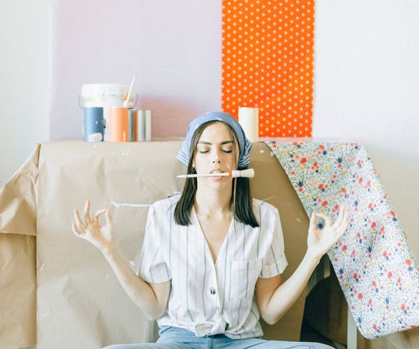 A woman meditating peacefully in a bright, minimalist room.